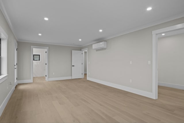 spare room featuring a wall unit AC, crown molding, and light wood-type flooring