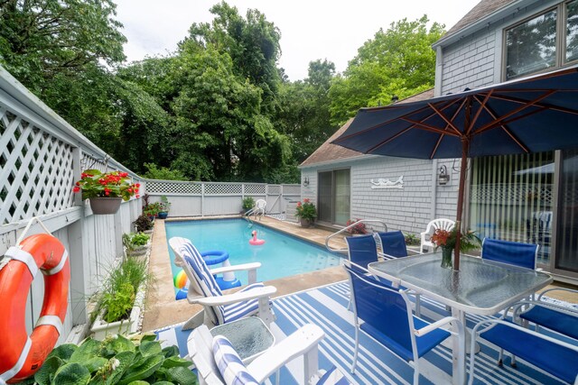 view of swimming pool with a fenced in pool, outdoor dining area, a fenced backyard, and a patio