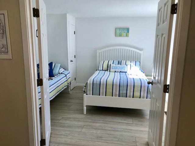 bedroom featuring baseboards and wood finished floors