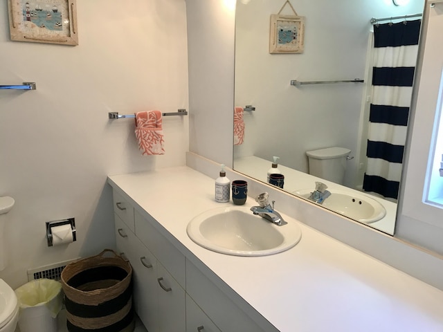 full bath featuring a shower with shower curtain, vanity, and toilet