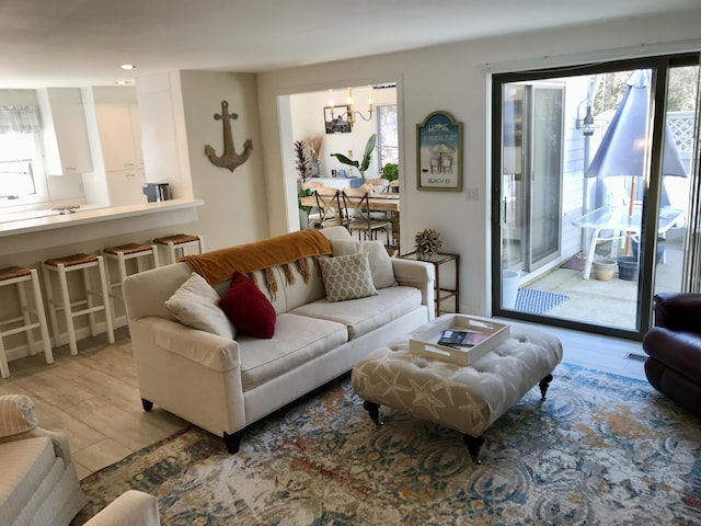 living area with recessed lighting, a notable chandelier, and wood finished floors