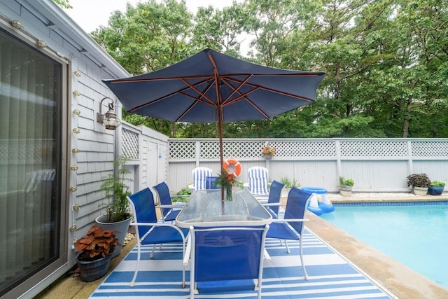 exterior space featuring a fenced in pool, outdoor dining space, and a fenced backyard