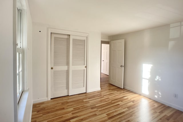 unfurnished bedroom featuring light hardwood / wood-style floors and a closet