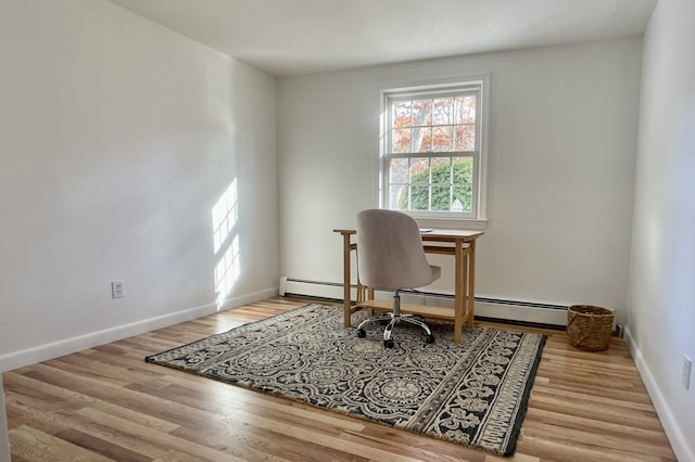 office space featuring baseboard heating and light hardwood / wood-style flooring