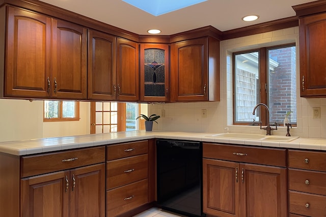 kitchen with tasteful backsplash, dishwasher, sink, kitchen peninsula, and tile countertops