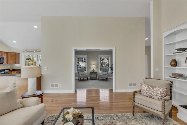 living room featuring light hardwood / wood-style floors and vaulted ceiling