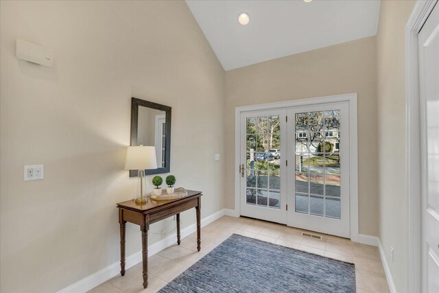 entryway with vaulted ceiling and light tile patterned floors