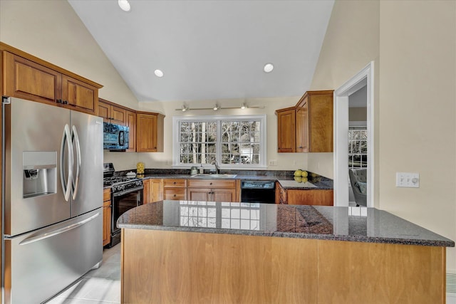 kitchen featuring black appliances, dark stone countertops, sink, vaulted ceiling, and light tile patterned floors