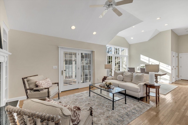 living room with ceiling fan, light hardwood / wood-style floors, lofted ceiling, and french doors