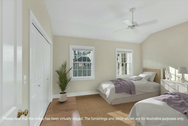 bedroom with hardwood / wood-style floors, a closet, vaulted ceiling, and ceiling fan