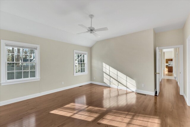 unfurnished room with ceiling fan, hardwood / wood-style floors, and vaulted ceiling