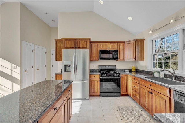 kitchen with black appliances, dark stone counters, high vaulted ceiling, and sink