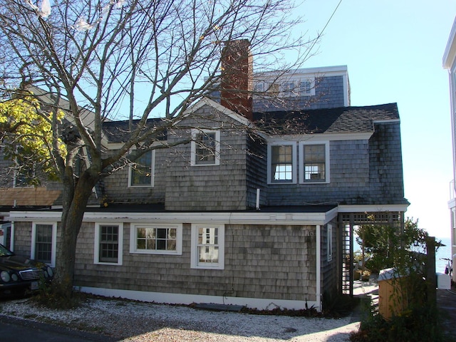 view of home's exterior featuring a shingled roof and a chimney