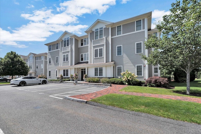 view of front of home featuring uncovered parking and a front yard