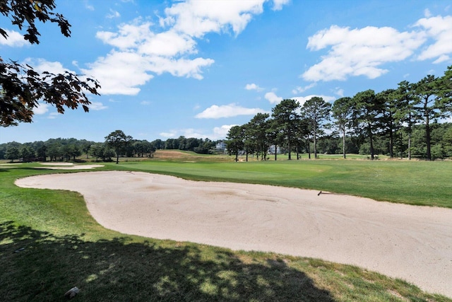 view of home's community with view of golf course and a yard