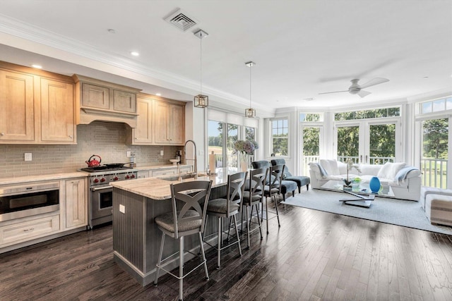 kitchen featuring a sink, visible vents, open floor plan, high end range, and built in microwave