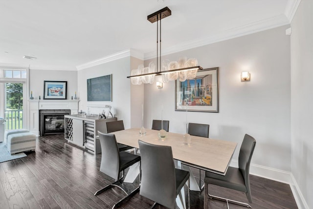 dining room featuring ornamental molding, a glass covered fireplace, dark wood finished floors, and baseboards