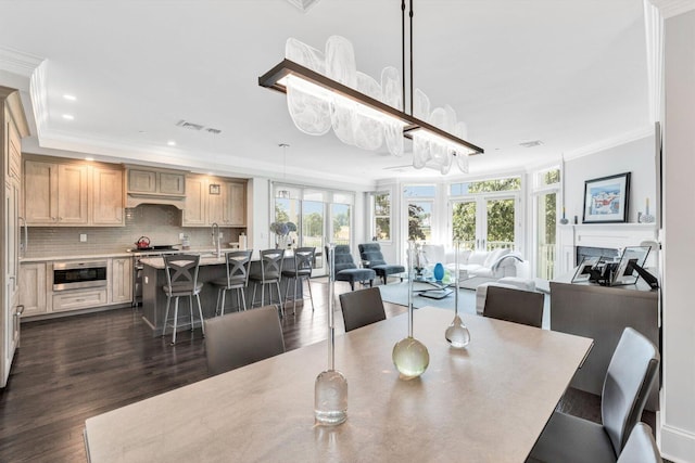 dining area featuring visible vents, dark wood finished floors, ornamental molding, a fireplace, and recessed lighting