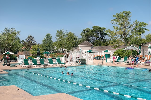 community pool with fence and a patio