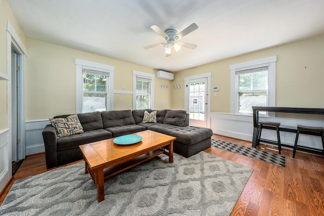 301 Main St, Dennis Port, MA 02639 - living area with a wall mounted AC, wood finished floors, healthy amount of natural light, ceiling fan, and wainscoting