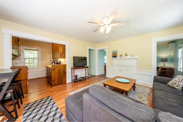 301 Main St, Dennis Port, MA 02639 - living area featuring a ceiling fan, wainscoting, a wall mounted AC, and light wood-style floors