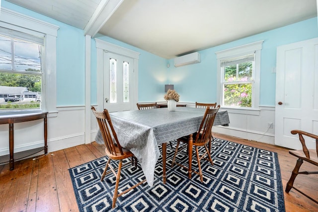 301 Main St, Dennis Port, MA 02639 - dining space featuring an AC wall unit, hardwood / wood-style flooring, beamed ceiling, and a wainscoted wall