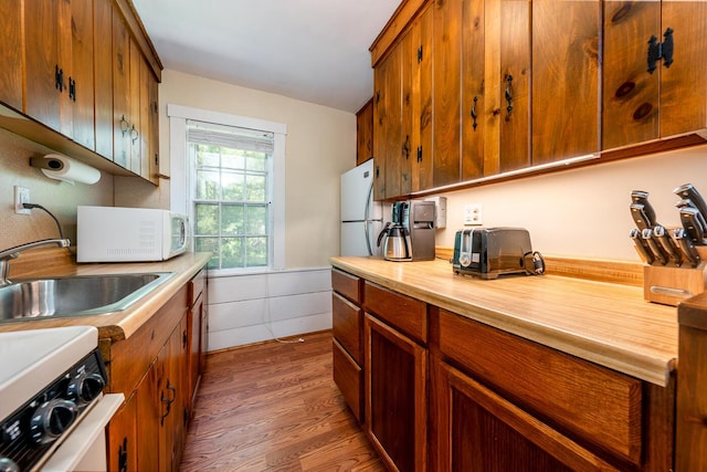 301 Main St, Dennis Port, MA 02639 - kitchen with white appliances, a sink, light countertops, wood finished floors, and wainscoting