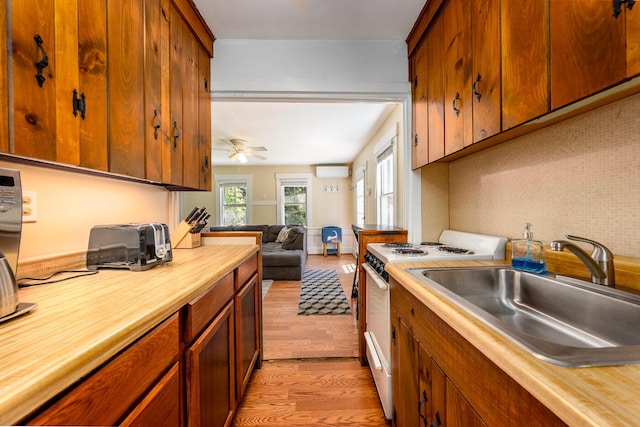 301 Main St, Dennis Port, MA 02639 - kitchen featuring electric stove, a sink, light wood-style floors, a wall unit AC, and ceiling fan