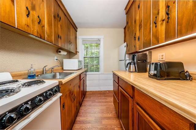 301 Main St, Dennis Port, MA 02639 - kitchen with white appliances, a sink, light countertops, brown cabinets, and tasteful backsplash