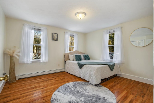 bedroom with hardwood / wood-style flooring and a baseboard radiator