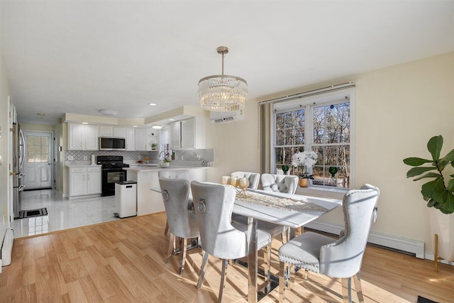 dining area with plenty of natural light, sink, and light hardwood / wood-style floors