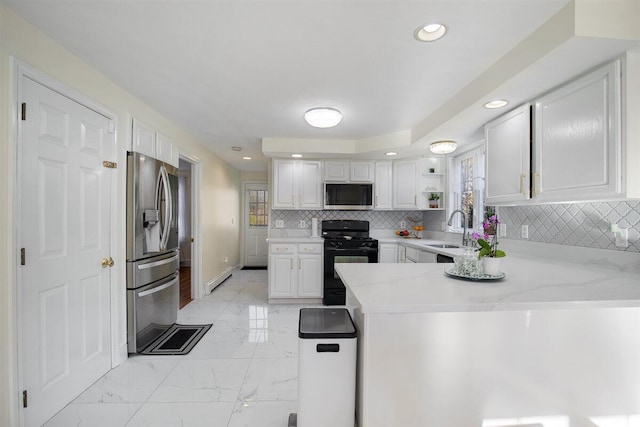 kitchen with appliances with stainless steel finishes, tasteful backsplash, sink, white cabinets, and kitchen peninsula