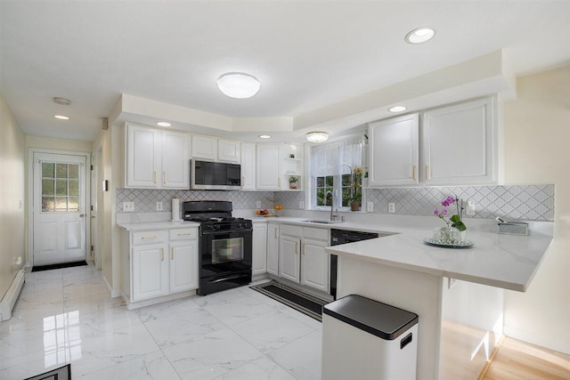 kitchen featuring sink, white cabinetry, black appliances, a kitchen bar, and kitchen peninsula