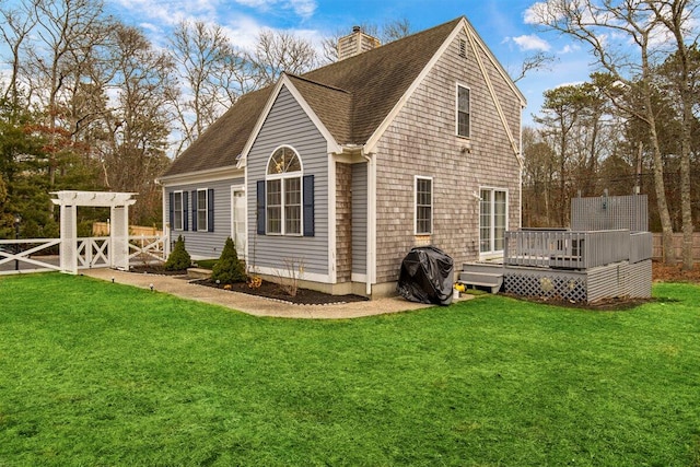 back of house featuring a wooden deck and a lawn