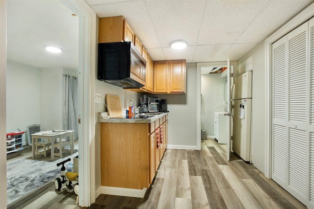 kitchen featuring white refrigerator, a paneled ceiling, and light hardwood / wood-style flooring