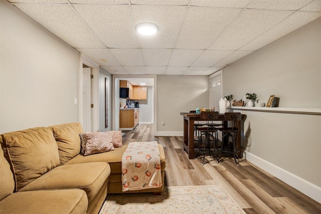 living room featuring hardwood / wood-style flooring and a drop ceiling