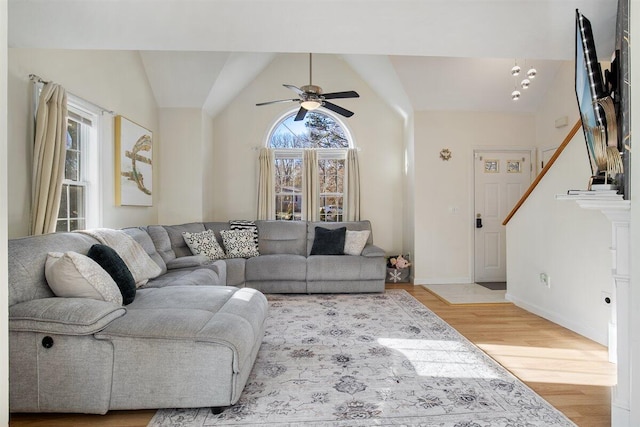 living room featuring lofted ceiling, light hardwood / wood-style flooring, and ceiling fan