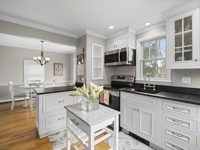 17 Edwards Rd, Hyannis, MA 02601 - kitchen with ornamental molding, dark countertops, white cabinetry, a sink, and stainless steel appliances