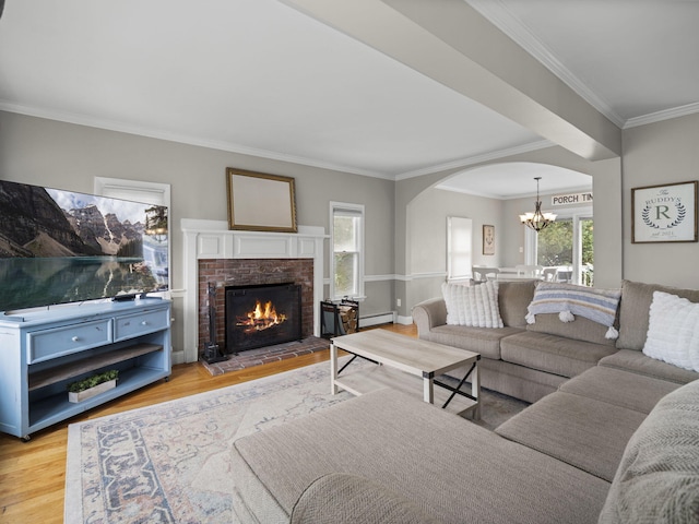 17 Edwards Rd, Hyannis, MA 02601 - living area featuring an inviting chandelier, ornamental molding, light wood-style floors, a baseboard radiator, and arched walkways