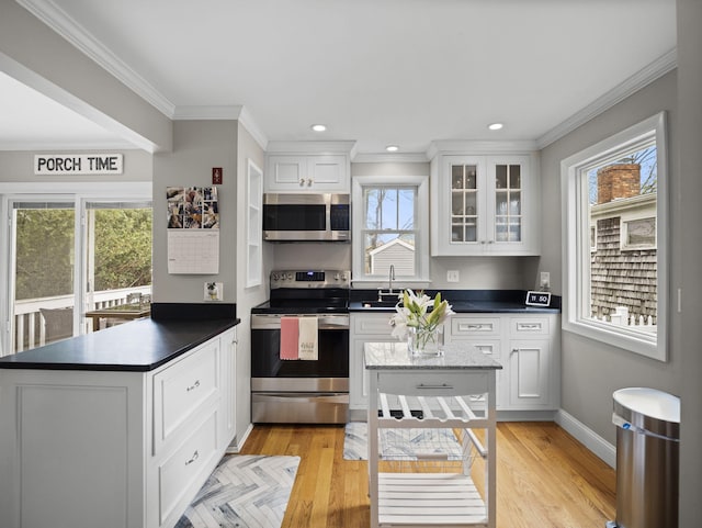 17 Edwards Rd, Hyannis, MA 02601 - kitchen with white cabinets, a sink, stainless steel appliances, a peninsula, and ornamental molding