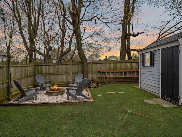 17 Edwards Rd, Hyannis, MA 02601 - view of yard with an outdoor structure, a fenced backyard, a fire pit, and a storage unit