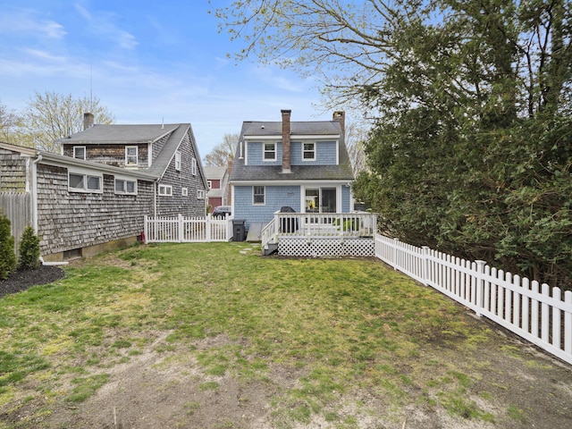 17 Edwards Rd, Hyannis, MA 02601 - back of house featuring a yard, a wooden deck, a fenced backyard, and a chimney