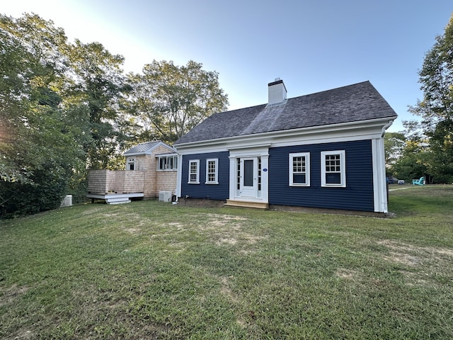 back of property featuring a lawn and a chimney