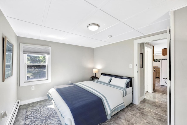 bedroom featuring baseboard heating and a drop ceiling