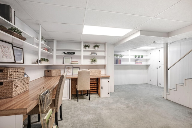 home office featuring built in desk, light carpet, and a drop ceiling