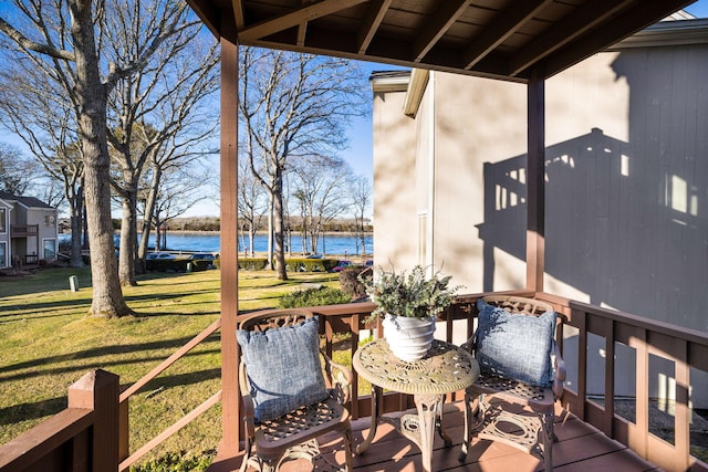 wooden deck with a water view and a yard