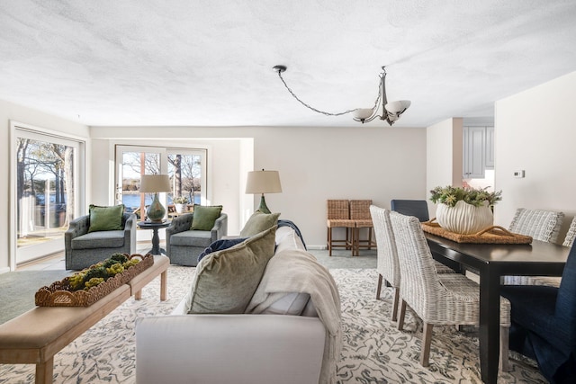 carpeted living room featuring a textured ceiling and a chandelier