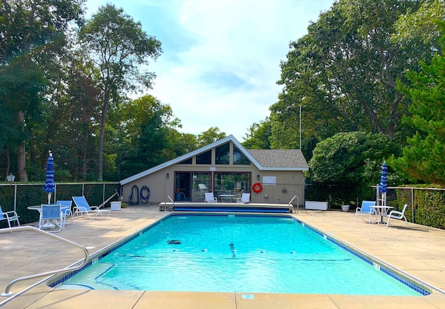 view of swimming pool featuring an outbuilding and a patio area