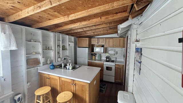 kitchen featuring beam ceiling, white appliances, light countertops, brown cabinets, and a sink
