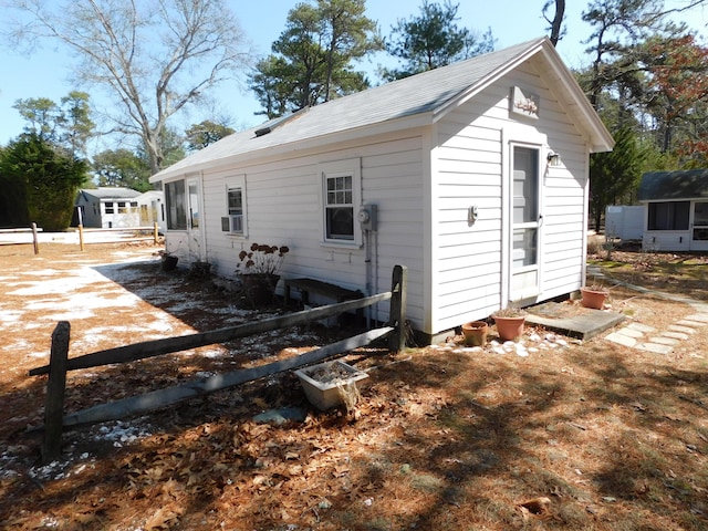 exterior space with fence, an outdoor structure, and cooling unit